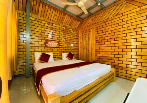 a bedroom with a bed in a brick wall at Falling Water Resort By Travent Mug in Sakleshpur