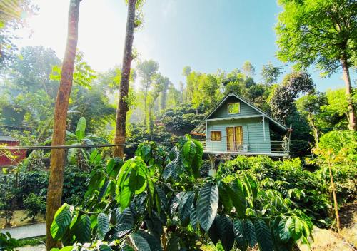 a small house in the middle of a forest at Falling Water Resort By Travent Mug in Sakleshpur