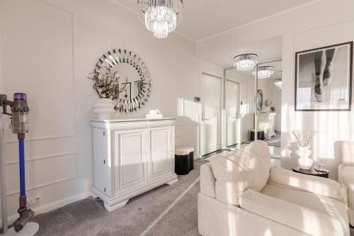 a living room with white furniture and a mirror at Luxury and cozy apartment with a beautiful view in Bucharest