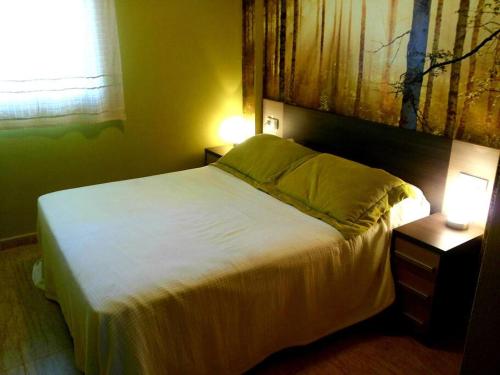 a bedroom with a white bed with two night stands at Apartamento con piscina a pocos metros de la playa in Moncófar