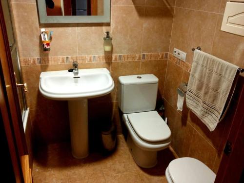 a bathroom with a white toilet and a sink at Apartamento con piscina a pocos metros de la playa in Moncófar