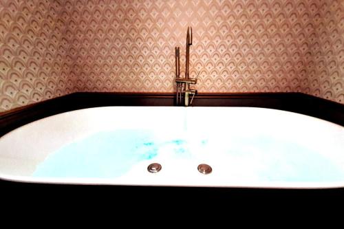 bañera blanca con grifo en el baño en Da Vinci Apartment Paris Montmartre AirCon, en París
