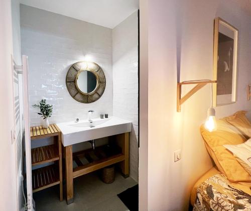 a bathroom with a sink and a mirror next to a bed at L'OlivierBlanc in Vendémian