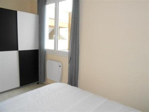 um quarto com uma cama branca e uma janela em Appartement Saint-Hilaire-de-Riez, 3 pièces, 6 personnes - FR-1-324A-21 em Saint-Hilaire-de-Riez
