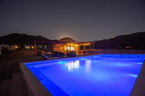 una piscina por la noche con cenador en Denmoza Eco Lodge en Potrerillos