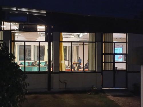 a house with windows at night with a person sitting at a table at Shivir Aranya - Wilderness Resort in Alwar