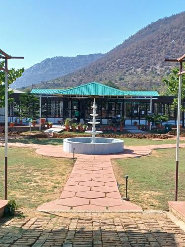 a fountain in a park in front of a building at Shivir Aranya - Wilderness Resort in Alwar