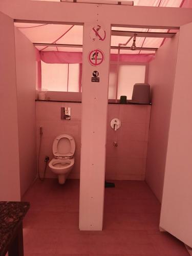 a bathroom with a toilet in a pink room at Shivir Aranya - Wilderness Resort in Alwar
