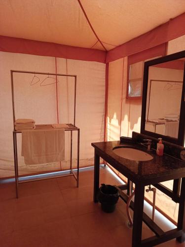 a bathroom with a table with a mirror and a sink at Shivir Aranya - Wilderness Resort in Alwar