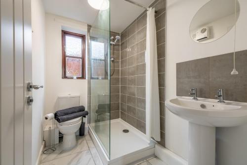 a bathroom with a shower and a sink and a toilet at Modern studio flat in Wellington, Telford in Wellington