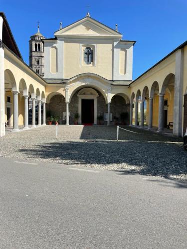 a large building with a church with a clock tower at Lakeside Apartment in Gravedona