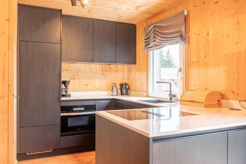 eine Küche mit braunen Schränken und einer Arbeitsplatte in der Unterkunft Alpendorf Dachstein West by ALPS RESORTS in Annaberg im Lammertal