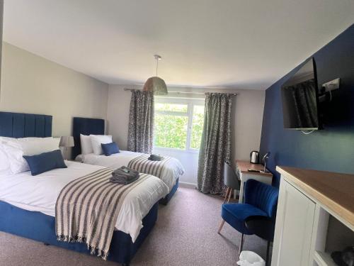 ein Hotelzimmer mit 2 Betten und einem Fenster in der Unterkunft Anchor Inn in Taunton