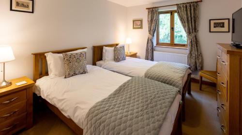 een slaapkamer met 2 bedden en een raam bij Heads Nook Hall Cottage in Carlisle