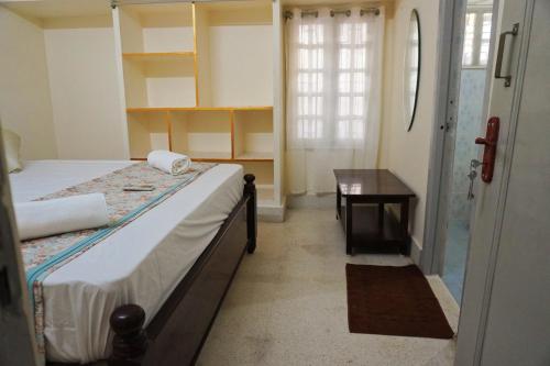 a bedroom with a bed and a table and a desk at ABS Home Stay, 2Bed room AC Flats,Tirupati in Tirupati