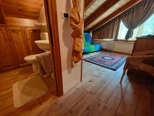 a bathroom with a toilet and a sink in a room at Hostdomus - Chalet Sciatori Loft in Pragelato