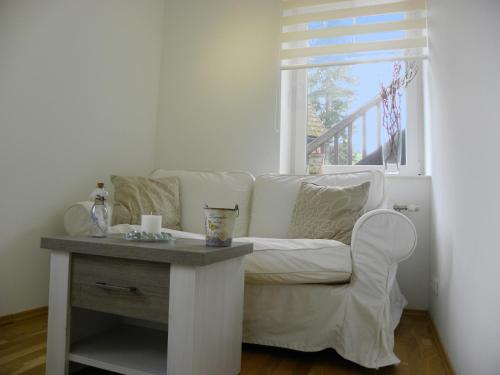 a living room with a white couch and a window at Landhaus Semmering in Semmering