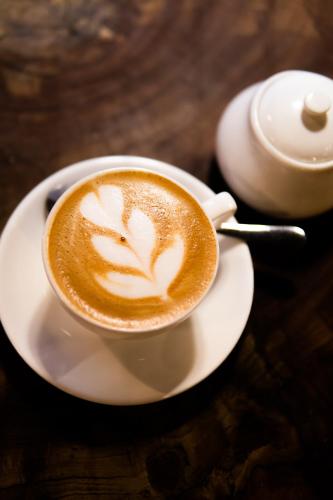 a cup of coffee on a plate on a table at Oxygen Paje Hotel in Paje