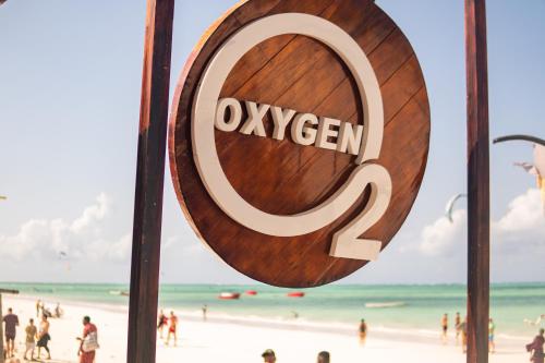 a sign at the beach with people on the beach at Oxygen Paje Hotel in Paje