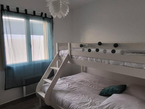 une chambre avec un lit superposé et une fenêtre dans l'établissement Villa 2 chambres au bord de mer avec accès direct plage, terrasse et parking privé - Grau d'Agde - FR-1-749-40, au Grau-dʼAgde