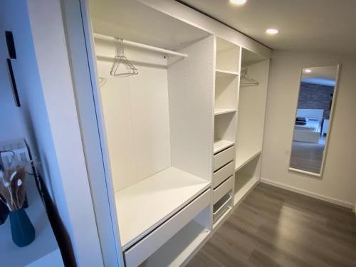 a walk in closet with white cabinets and a mirror at Design Immo Ferienwohnung Rhein-Main Rodgau in Rodgau