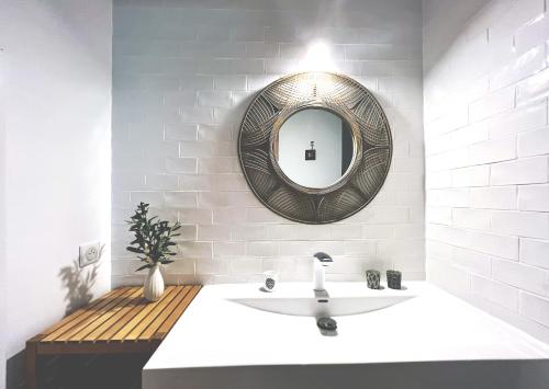une salle de bain avec un lavabo et un miroir au mur dans l'établissement L'OlivierBlanc, à Vendémian