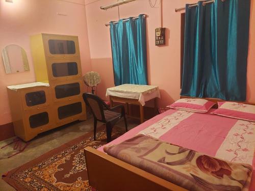a bedroom with two beds and a table and a chair at Roadji Stays 001, Madhuri Villa in Agartala