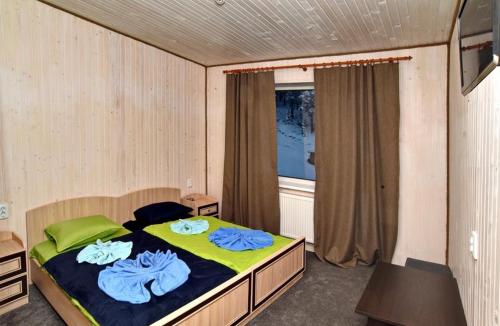 Готель Міленіум في دراغوبرات: غرفة نوم بسرير وملاءات زرقاء ونافذة