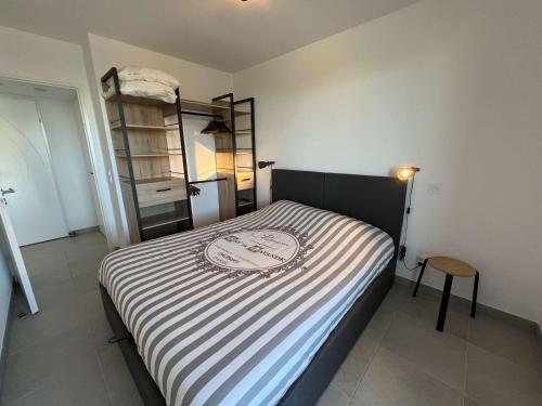 une chambre avec un lit avec une couette noire et blanche dans l'établissement Appartement T2 de standing, face mer, 4 pers, à 30m de la plage, parking privatif - FR-1-701-73, à Valras-Plage