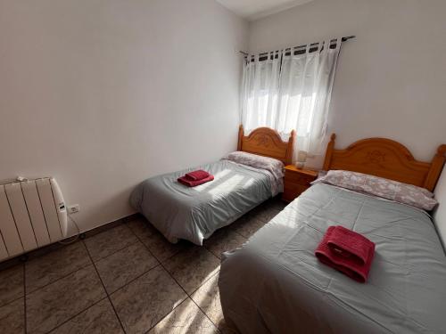 a bedroom with two beds with red towels on them at Apartamento La Ermita in Chulilla