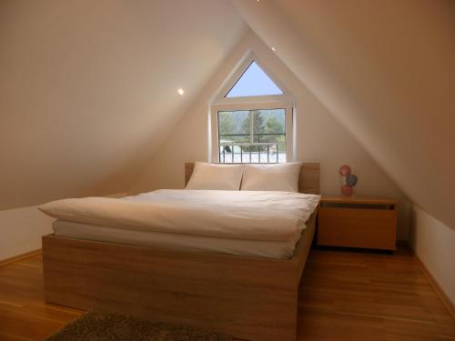 a bed in a room with a window at Landhaus Semmering in Semmering