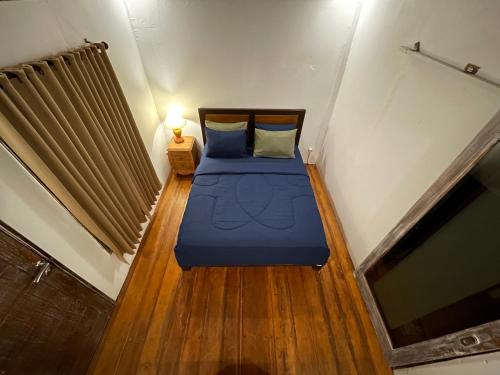 a small bedroom with a blue bed in a room at Rumah Tiga Gili in Gili Air
