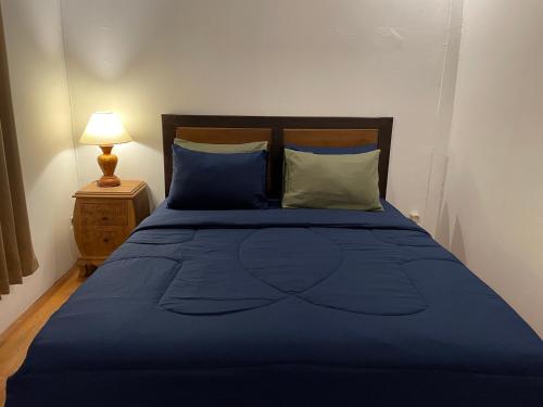 a blue bed with blue sheets and pillows at Rumah Tiga Gili in Gili Air