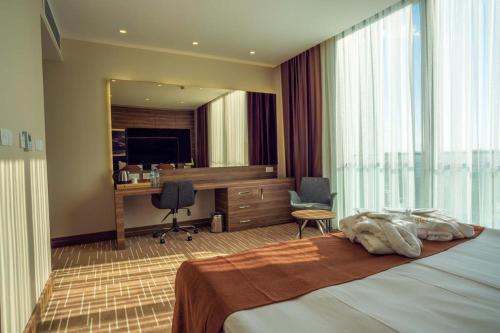 a hotel room with a bed and a desk at Ekor Elegance Hotel in Famagusta