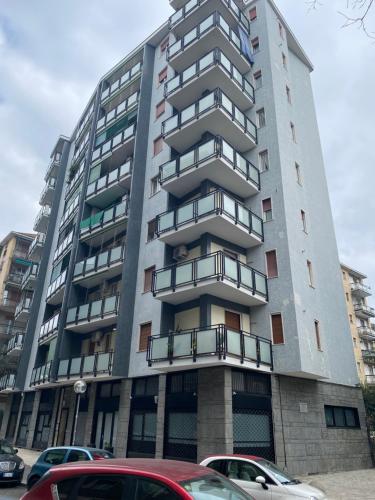 un edificio alto con coches estacionados frente a él en Casa Cavaleri Sweet apartment MM Bande Nere, en Milán