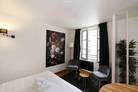 a room with a bed and chairs and a window at 302 - Séjournez dans un studio de charme à Paris 5 in Paris