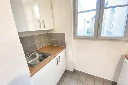 a small kitchen with a sink and a window at 103 - Studio jardins de plantes Paris 5 in Paris