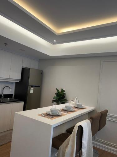 a kitchen with a white table with plates on it at Condotel in Abreeza Ayala Mall in Davao City