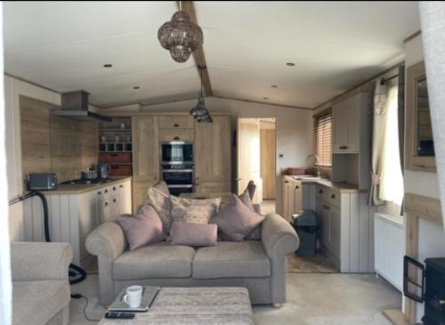 a living room with a couch and a kitchen at Orchard View Caravan in Boston