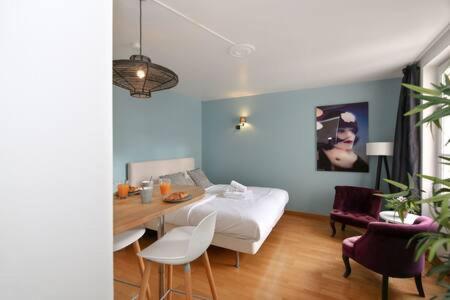 une chambre avec un lit, une table et des chaises dans l'établissement 402 -Studio élégant et confortable à Paris 5 - FLAT-GUEST, à Paris