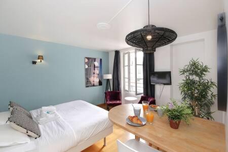 un salon avec un lit et une table dans l'établissement 402 -Studio élégant et confortable à Paris 5 - FLAT-GUEST, à Paris