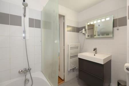 une salle de bain blanche avec un lavabo et une douche dans l'établissement 402 -Studio élégant et confortable à Paris 5 - FLAT-GUEST, à Paris