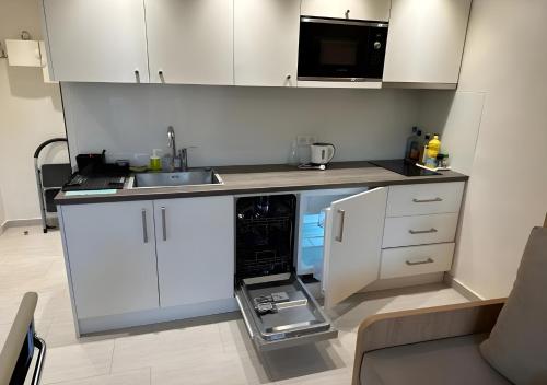 une petite cuisine avec des armoires blanches et un micro-ondes dans l'établissement Studio à proximité immédiate des transports avec une terrasse, à Cachan