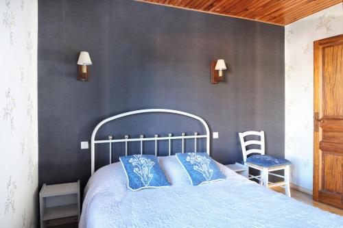 Un dormitorio con una cama azul y una pared gris en La Chaumière - Maison à moins d’un km de la plage, en Saint-Jean-de-la-Rivière