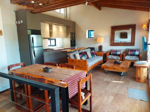 kuchnia i salon ze stołem i kanapą w obiekcie Tres Vistas w mieście Bariloche