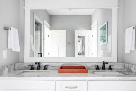 a bathroom with two sinks and a large mirror at The Porter - East Nash Lively Comfort, Dog-Friendly in Nashville