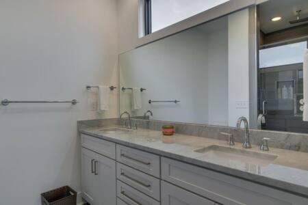 a bathroom with two sinks and a large mirror at The Kora - Stylish Rooftop Retreat in Gulch in Nashville