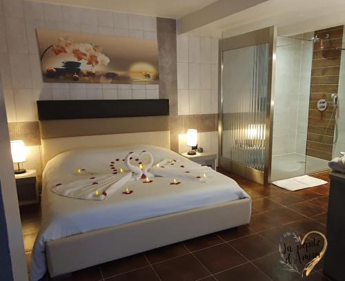 ein Schlafzimmer mit einem großen Bett und einer Dusche in der Unterkunft La pépite d'amour in Sainte-Anastasie-sur-Issole