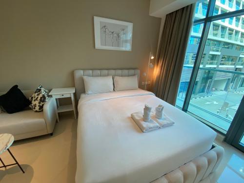 a bedroom with a large white bed and a couch at Black and white flower oasis in Seven Palm in Dubai