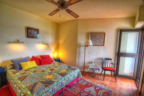 a bedroom with a bed and a ceiling fan at Hastinapura, acceso directo al mar in Es Castell